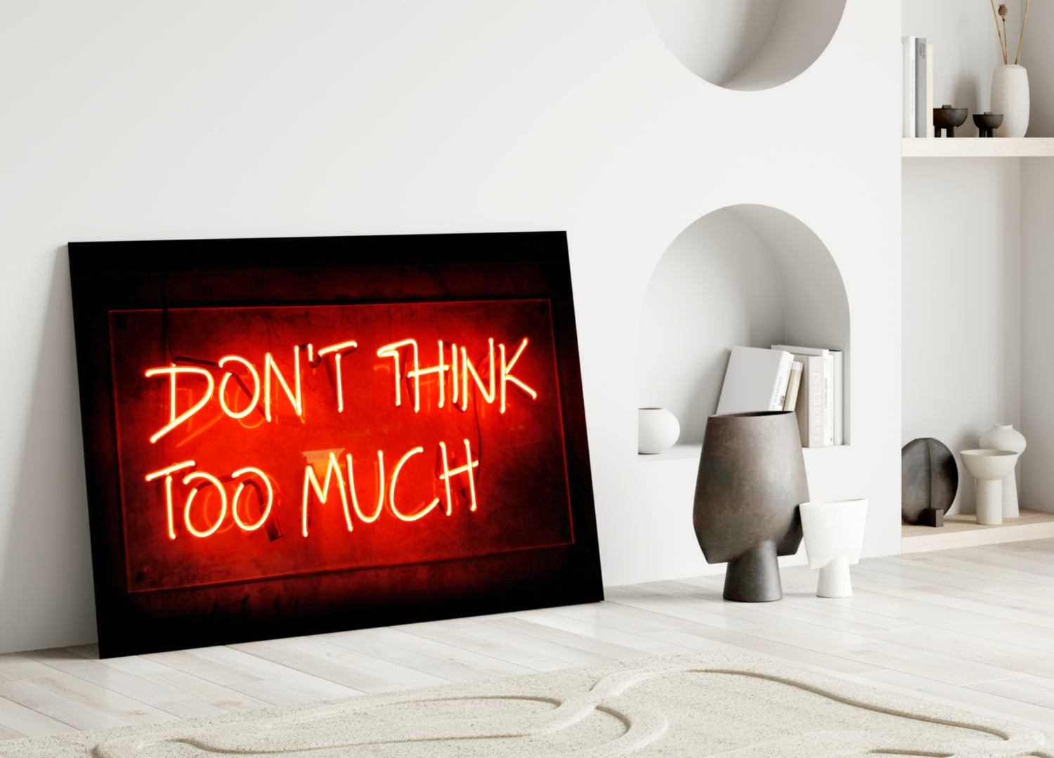 Red neon "Don't Think Too Much" sign displayed on white wall beside decorative ceramic objects and shelving.