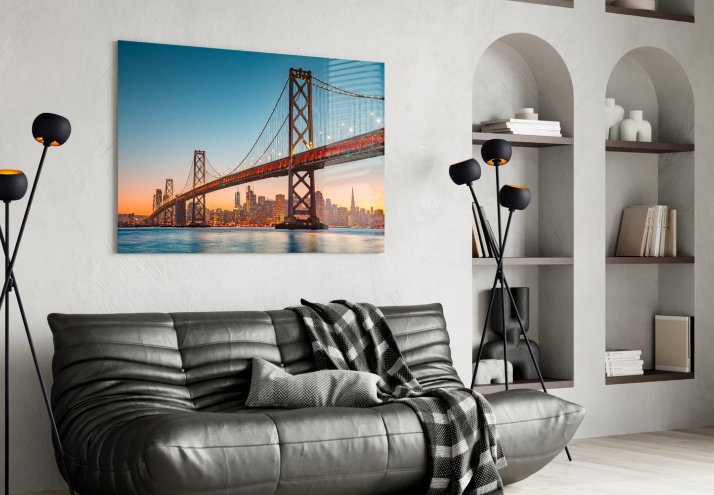 San Francisco Oakland Bay Bridge glass wall art displayed above black leather sofa in modern living room with built-in shelving.