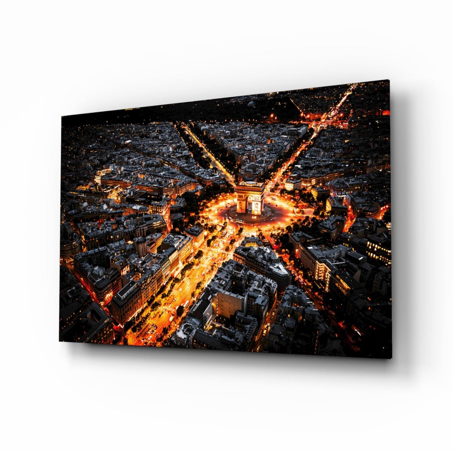 Aerial nighttime view of Paris with Arc de Triomphe illuminated at center, golden street lights radiating outward, mounted on glass panel.