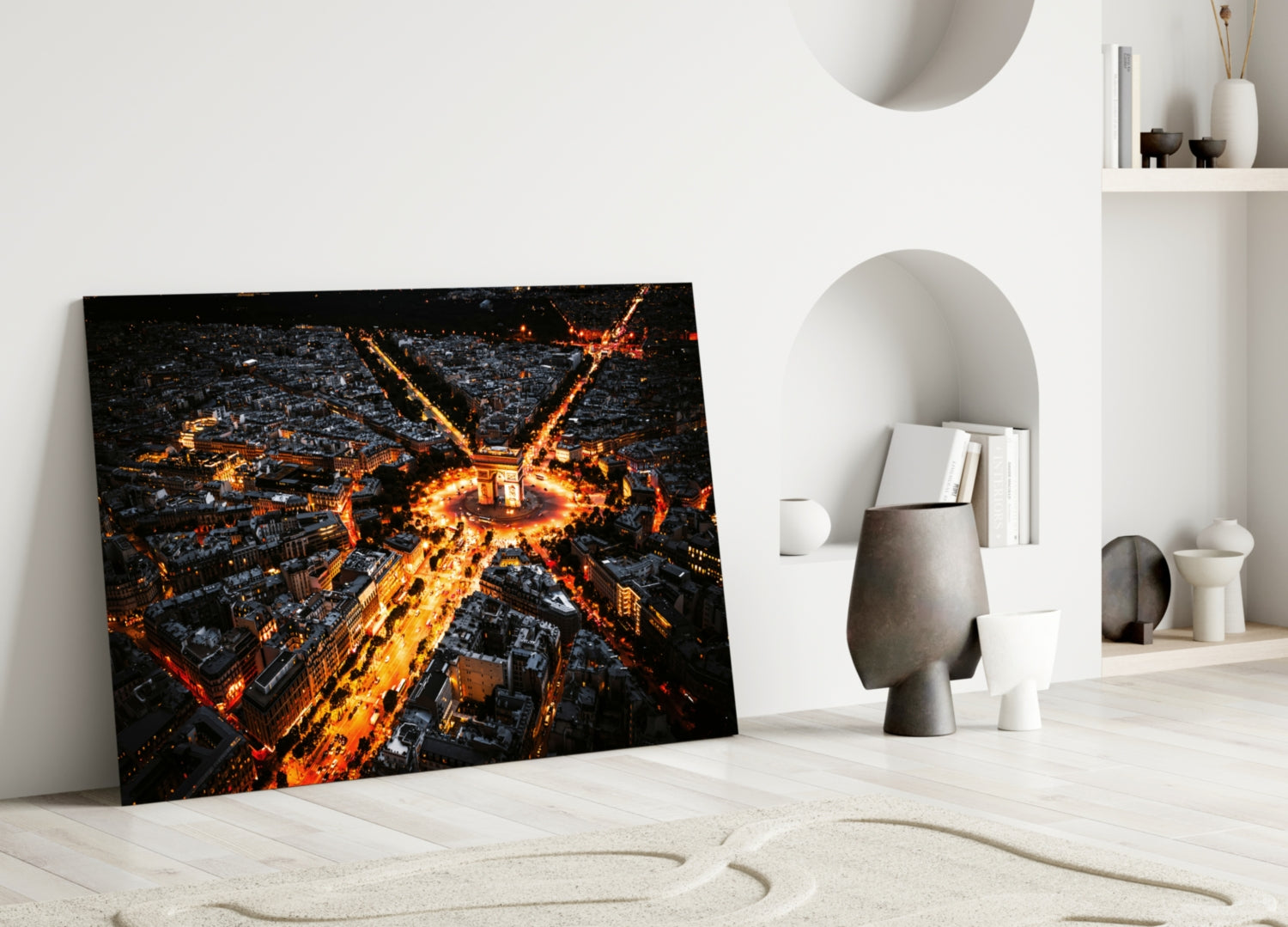 Aerial nighttime cityscape glass art leaning against white wall, glowing golden streets and buildings on black background.