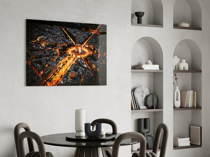 Aerial nighttime cityscape photograph on glass mounted above black dining table with grey chairs and white shelving unit.