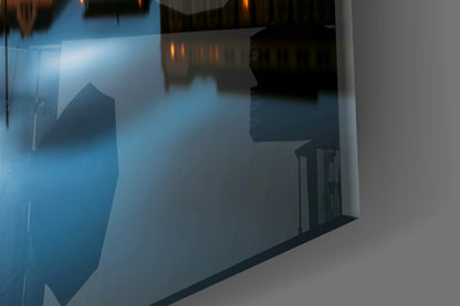 Frosted glass wall art displaying blue-toned architectural cityscape with silhouetted buildings and warm light reflections.