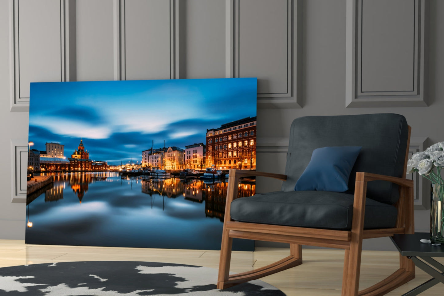 Glass wall art displaying illuminated Helsinki waterfront buildings at twilight, displayed in modern living room beside wooden chair.