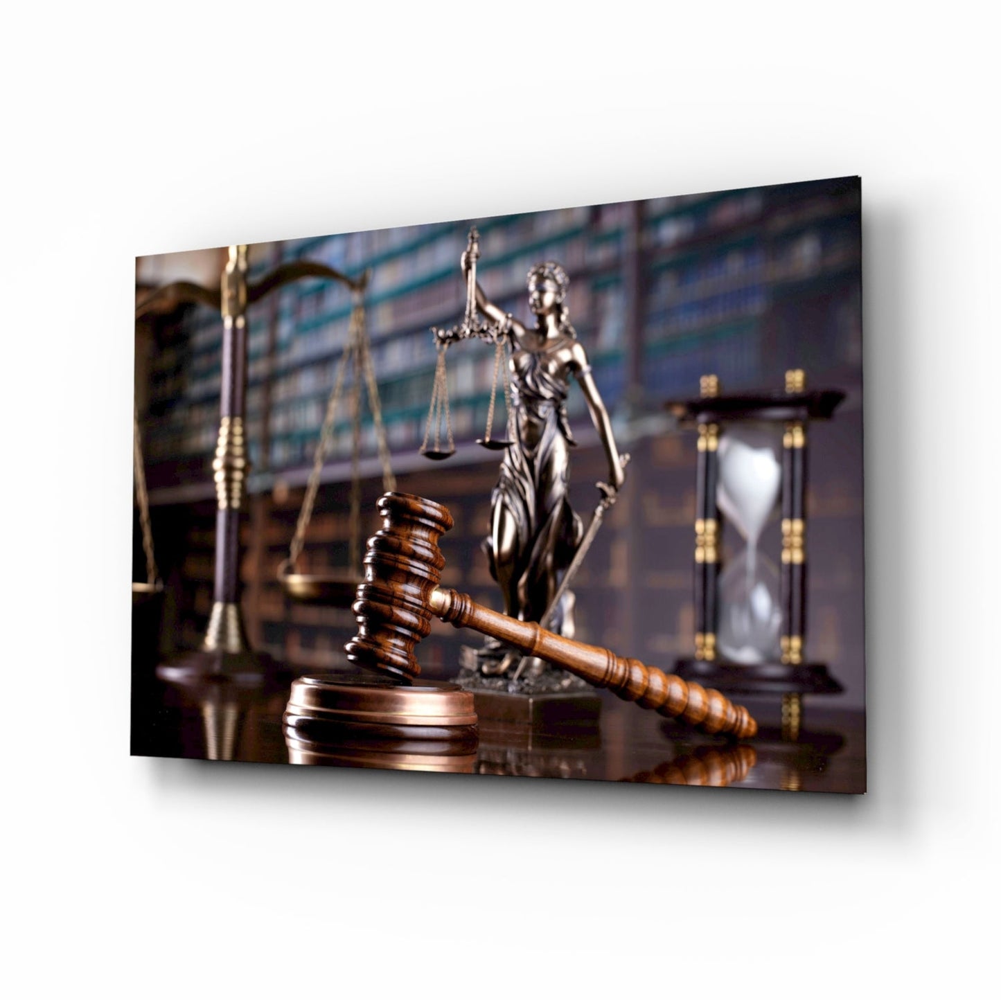 Wooden gavel and stack on desk with Lady Justice statue and scales in soft-focus background, courtroom setting.