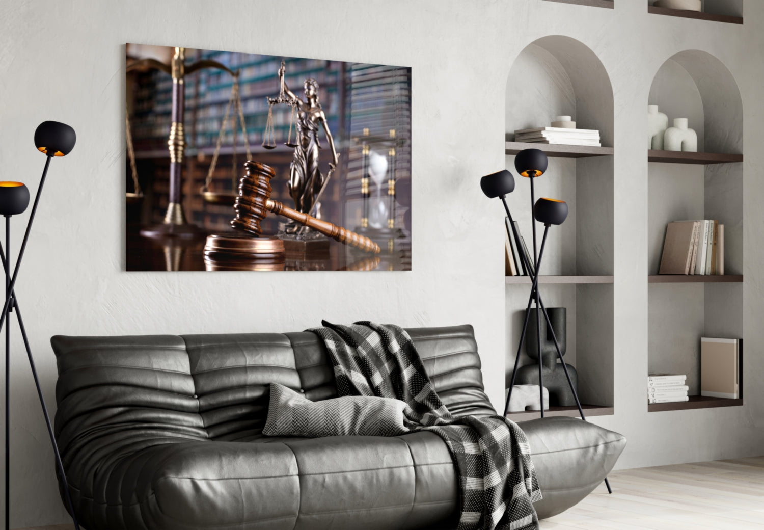 Glass wall art depicting a gavel and scales of justice displayed above a gray leather sofa in a modern legal office interior.