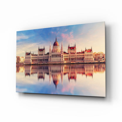 Hungarian Parliament Building reflected in still water at sunrise, printed on glass wall art panel with shadow effect.