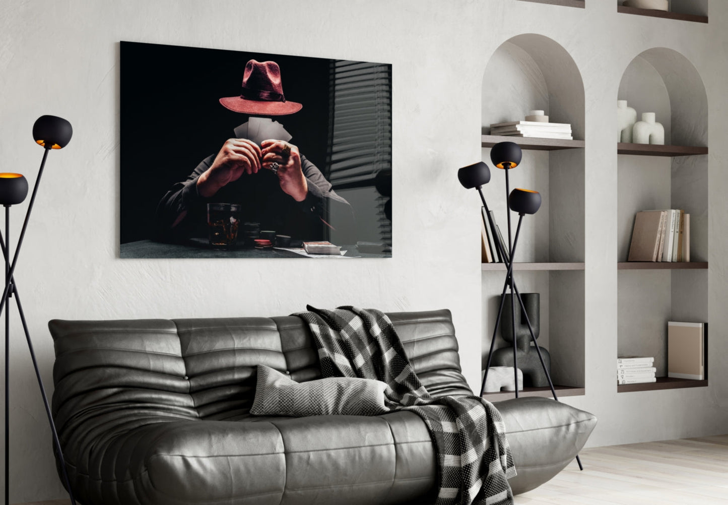 Black glass wall art depicting a figure in a red hat making a heart hand gesture, displayed above a gray leather sofa in a modern living room.