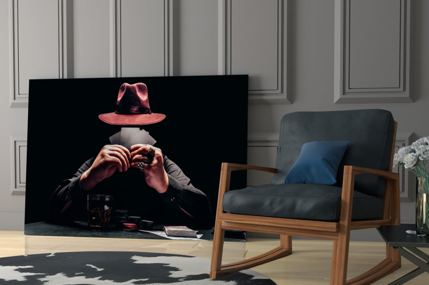 Glass wall art depicting a figure in a red hat and dark jacket holding playing cards, displayed in a modern living room next to a wooden chair.