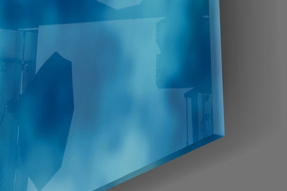 Blue-tinted glass wall art displaying architectural silhouettes and building shapes in layered translucent panels.