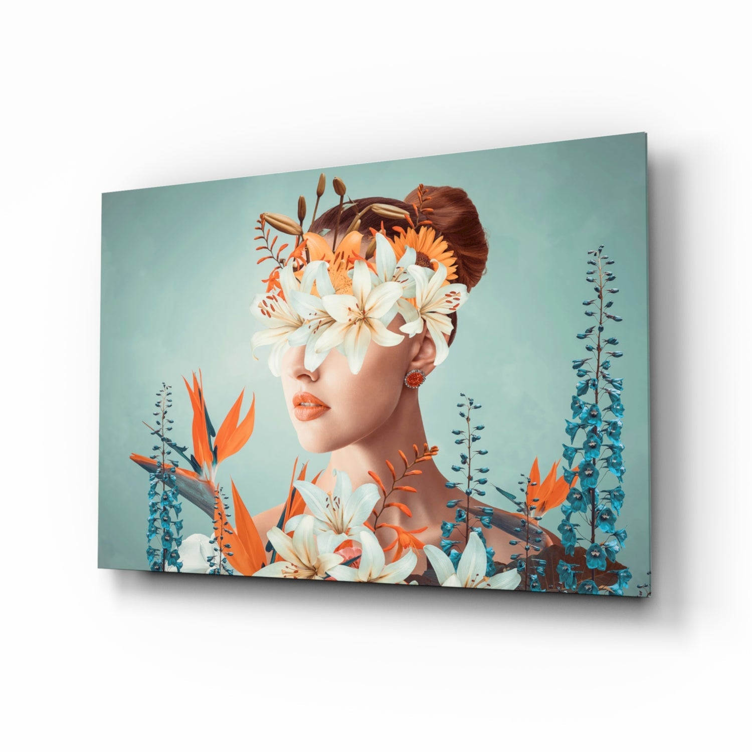 Woman's profile with white and orange lilies obscuring face against turquoise background on glass canvas, displayed at angle.