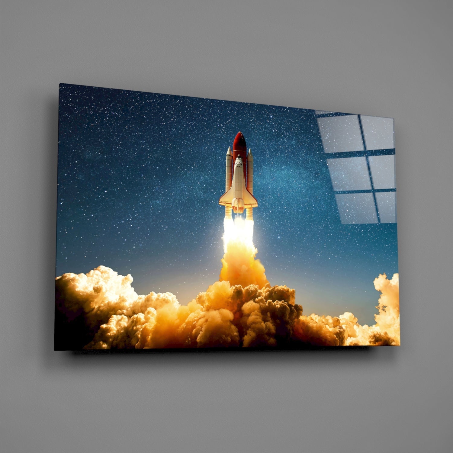 A space shuttle launching through golden clouds against a starry sky, displayed on angled glass wall art with solar panel details visible on the right edge.