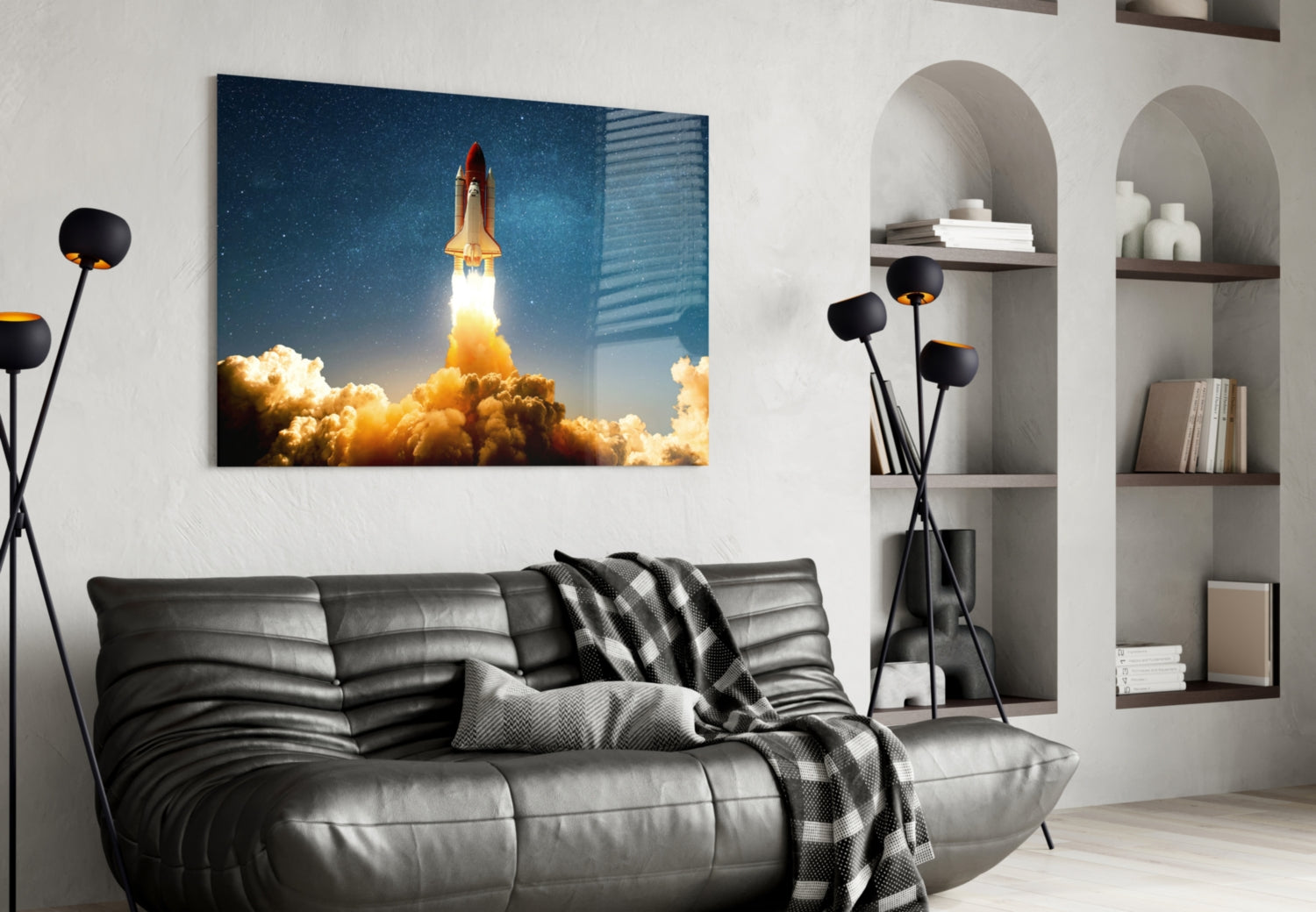 Space shuttle launching through golden clouds against starry sky displayed above black leather sofa in modern living room.