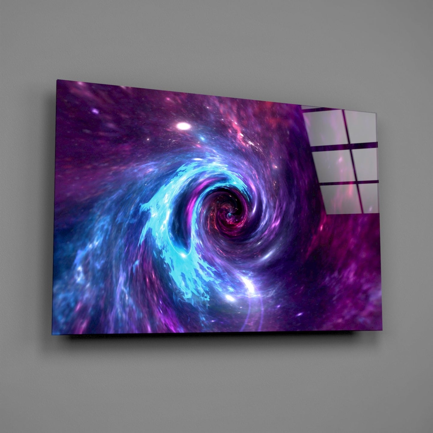 Wall-mounted glass art panel displaying a luminous purple and blue spiral galaxy vortex against gray wall background.