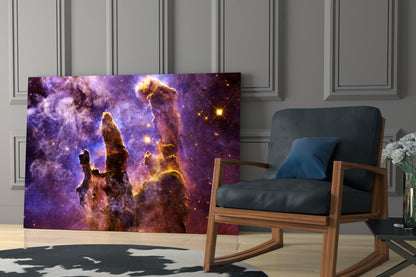 Space Lilac glass wall art displaying purple nebula with golden pillars installed in modern living room beside wooden chair.