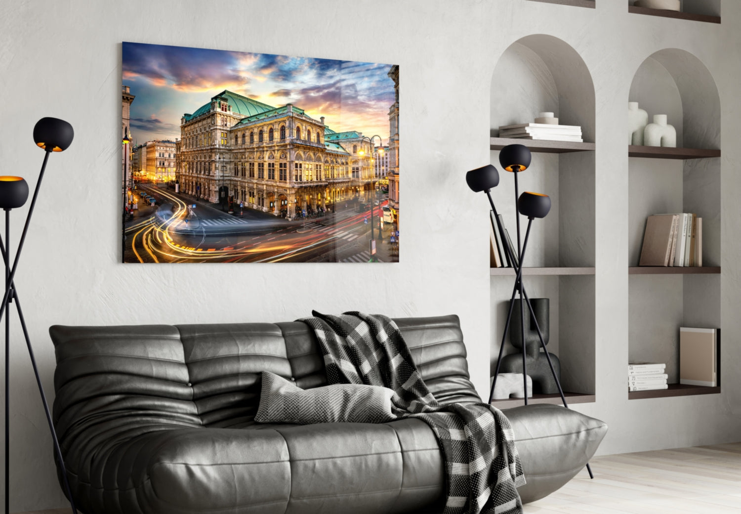 Vienna State Opera glass wall art displaying illuminated historic building with golden light trails, mounted above black leather sofa in modern living room.