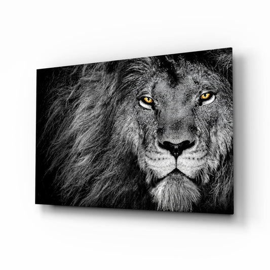 Black and white glass wall art featuring a lion's face in profile with striking amber eyes against dark background.