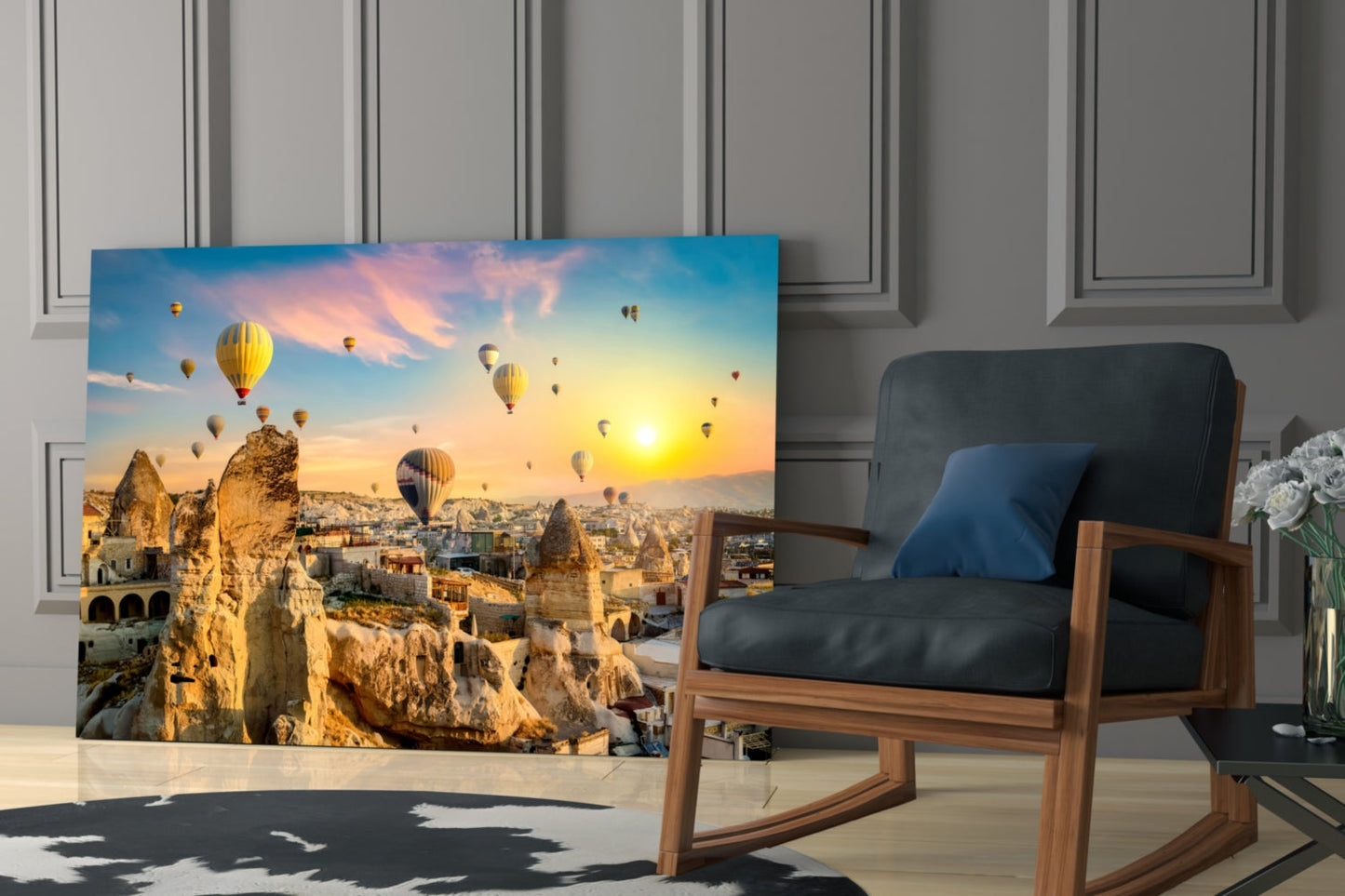 Glass wall art displaying Cappadocia hot air balloons at sunset displayed in modern living room beside wooden chair.