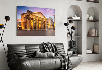 Pantheon glass wall art displayed above black leather sofa, showing illuminated Roman temple facade at twilight.