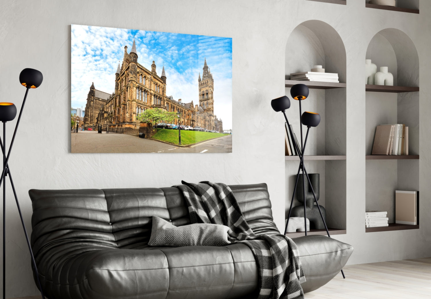 University of Glasgow glass wall art displaying golden sandstone buildings and clock tower mounted above black leather sofa in modern living room.