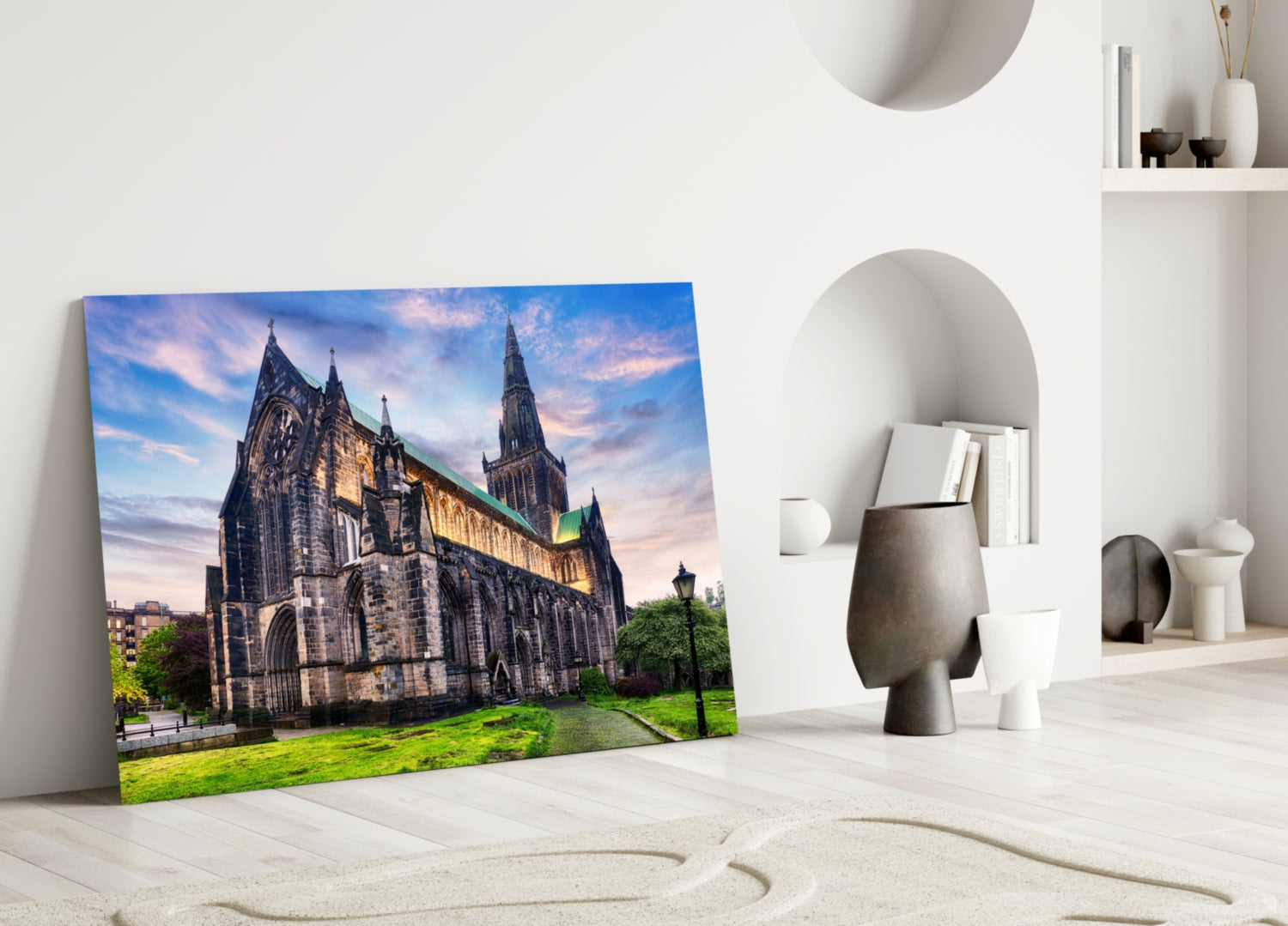 Glasgow Cathedral glass wall art leaning against white wall in minimalist interior with decorative objects.
