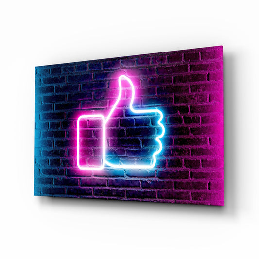 Neon thumbs-up sign glowing pink and blue against a brick wall texture on glass panel.