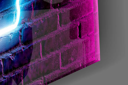 Close-up angle of textured glass wall art with cyan neon light on left edge and magenta illumination across brick-textured surface against gray background.