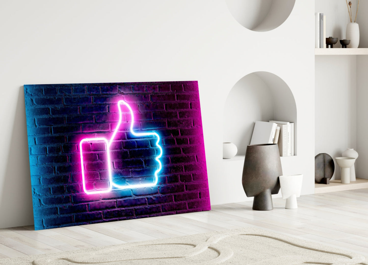 Neon thumbs-up sign in magenta and cyan glowing on dark brick backdrop, displayed leaning against white wall in minimalist room setting.