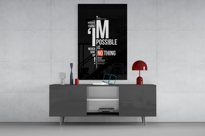 Black motivational glass wall art with white and red text displaying "I'm Possible" and "Never Give Up" mounted above a gray media console.