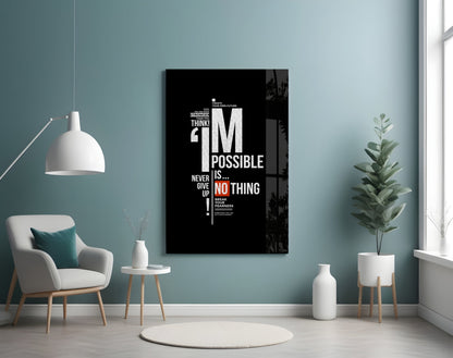 Black motivational glass wall art displaying white and red text reading "I'm Possible Is Nothing" mounted above a cream armchair in a teal room.