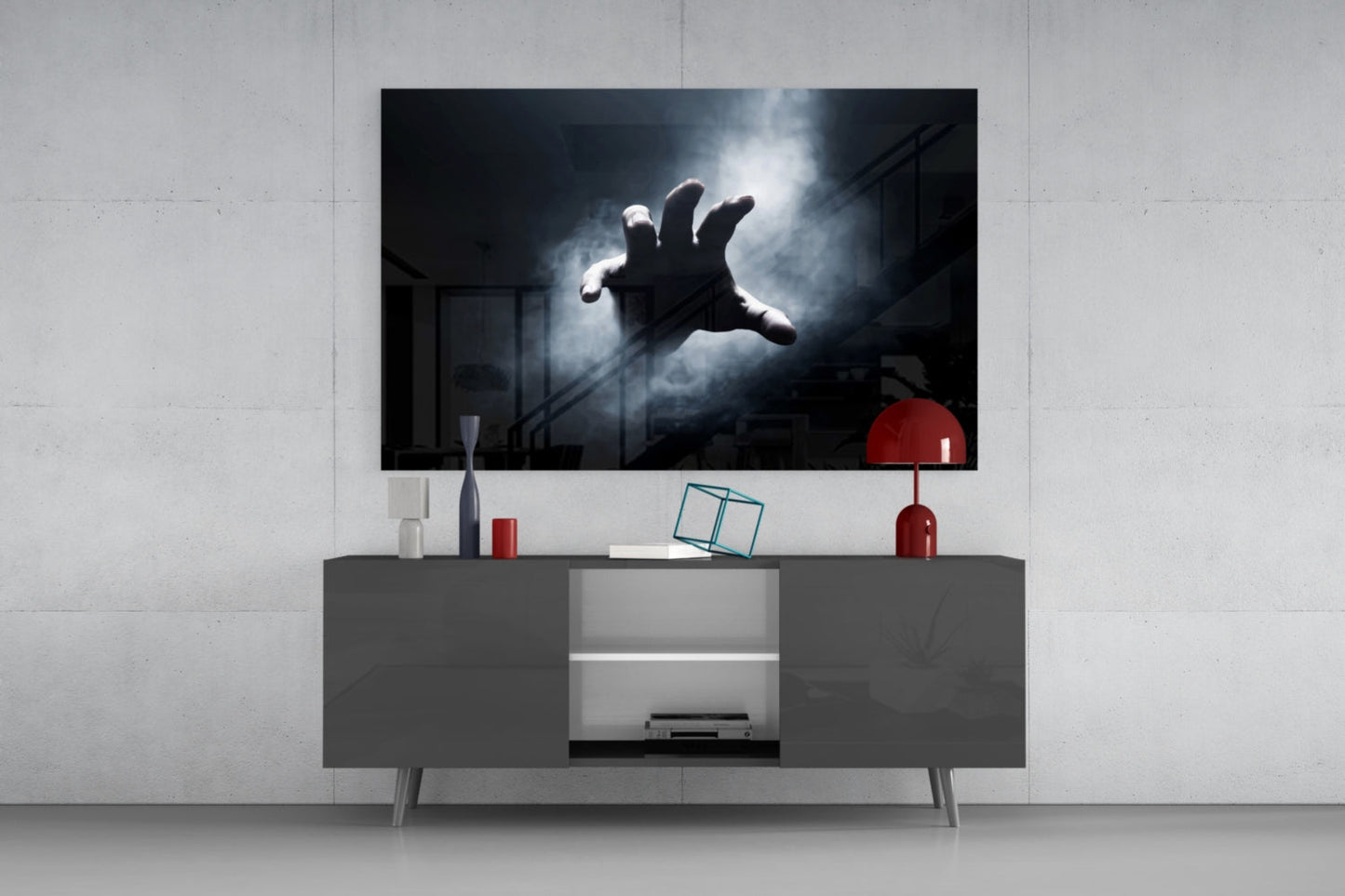 Fear Glass Wall Art mounted above gray media console displaying dramatic black and white image of outstretched hand against stormy sky.