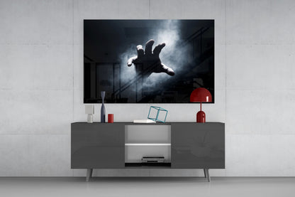 Fear Glass Wall Art mounted above gray media console displaying dramatic black and white image of outstretched hand against stormy sky.