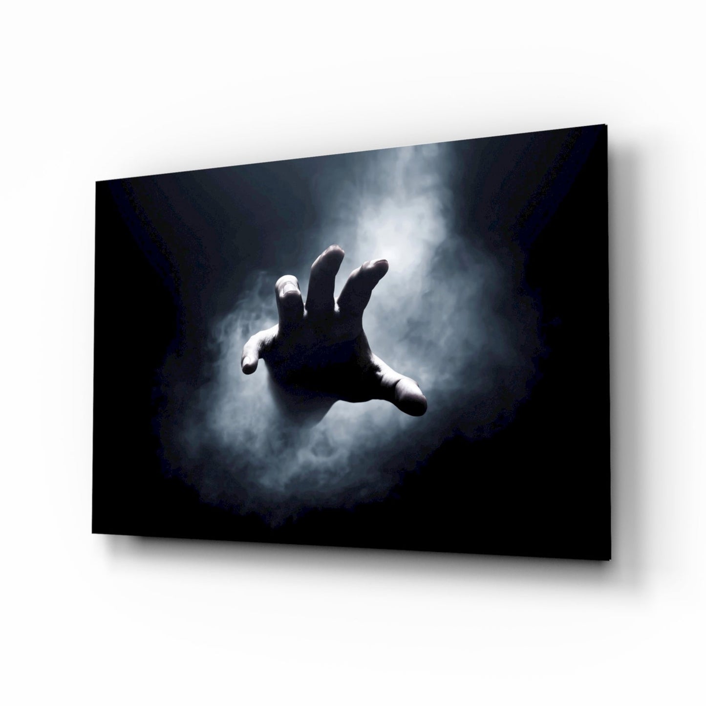Glass wall art panel displaying a reaching hand silhouetted against dramatic stormy clouds on dark background.