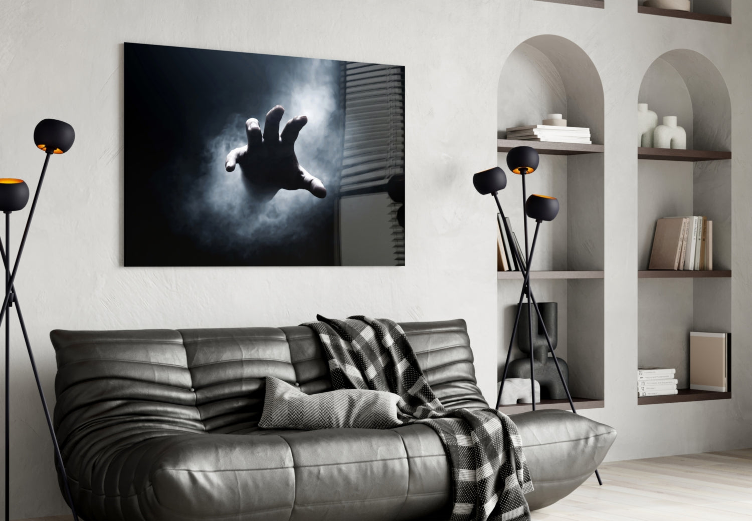 Black glass wall art depicting a silhouetted hand reaching toward light, displayed above a gray leather sofa in a modern living room.