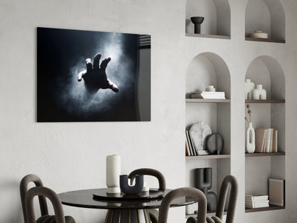 Modern minimalist dining room with black glass wall art depicting a dramatic silhouetted hand against stormy clouds.