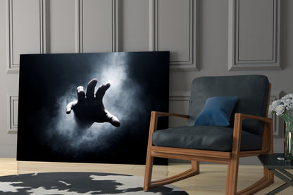 Fear Glass Wall Art displaying a silhouetted hand reaching toward light against a dark stormy background, mounted in modern living room interior.