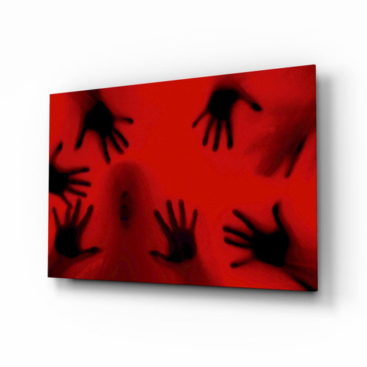 Angled perspective view of red glass wall art with seven black silhouetted hands pressed against surface, creating shadowy effect.