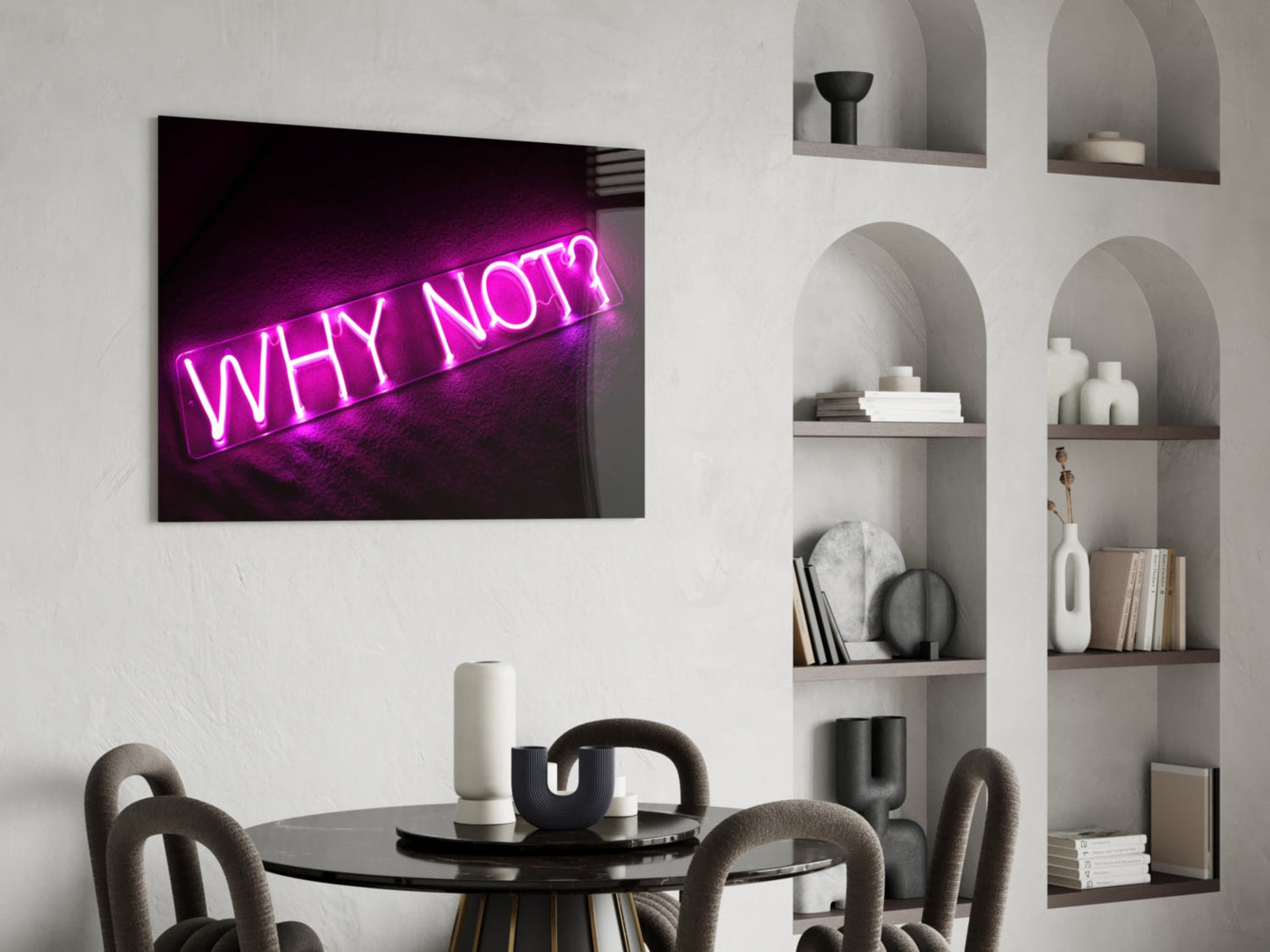Magenta neon "Why Not?" glass wall art displayed above a black round dining table in a modern white interior with arched shelving.