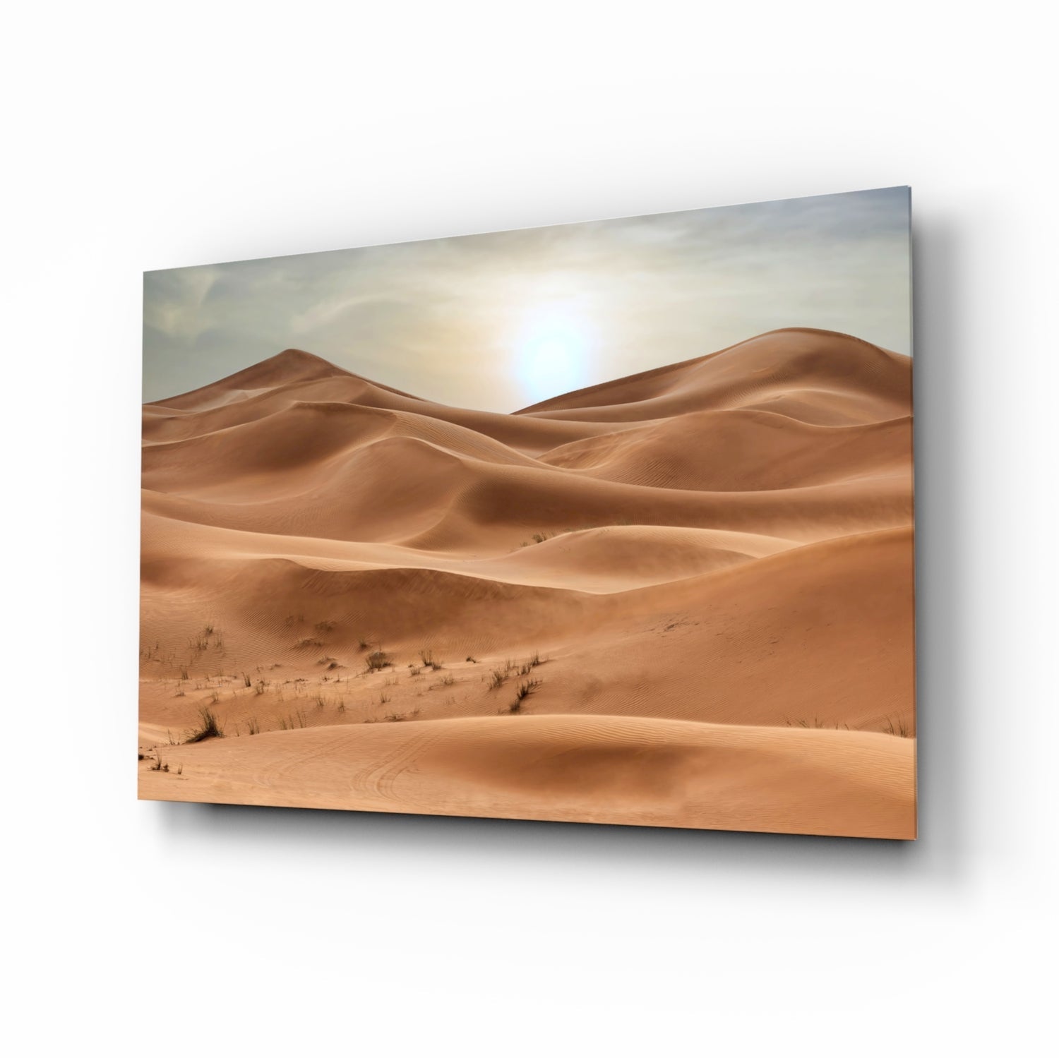 Glass wall art panel displaying rolling desert sand dunes under bright sunlight with sparse vegetation.