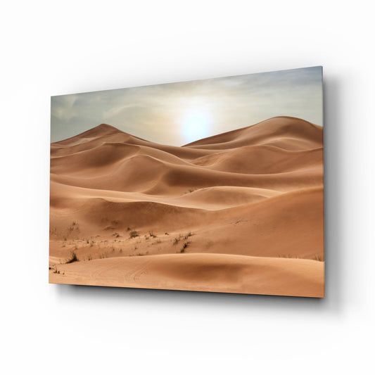 Glass wall art panel displaying rolling desert sand dunes under bright sunlight with sparse vegetation.