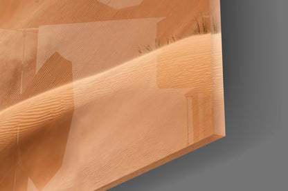 Close-up detail of textured glass surface showing warm peachy-tan tones and linear wood grain patterns against gray background.