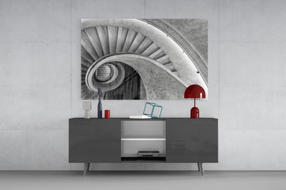 Black and white spiral staircase photograph displayed above dark gray media console with red decorative accents.