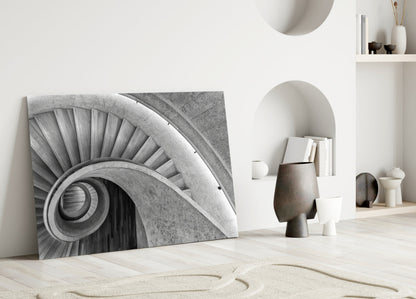Monochrome architectural glass art leaning against white wall displaying spiraling column detail with geometric background.