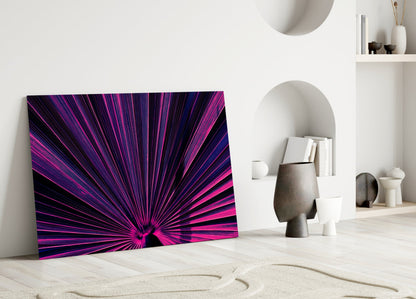 Vibrant neon pink and purple radial starburst pattern glass art leaning against white minimalist interior wall.