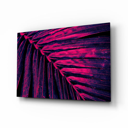 Angled perspective of neon magenta and dark blue fan palm fronds on glass wall art with shadow effect.