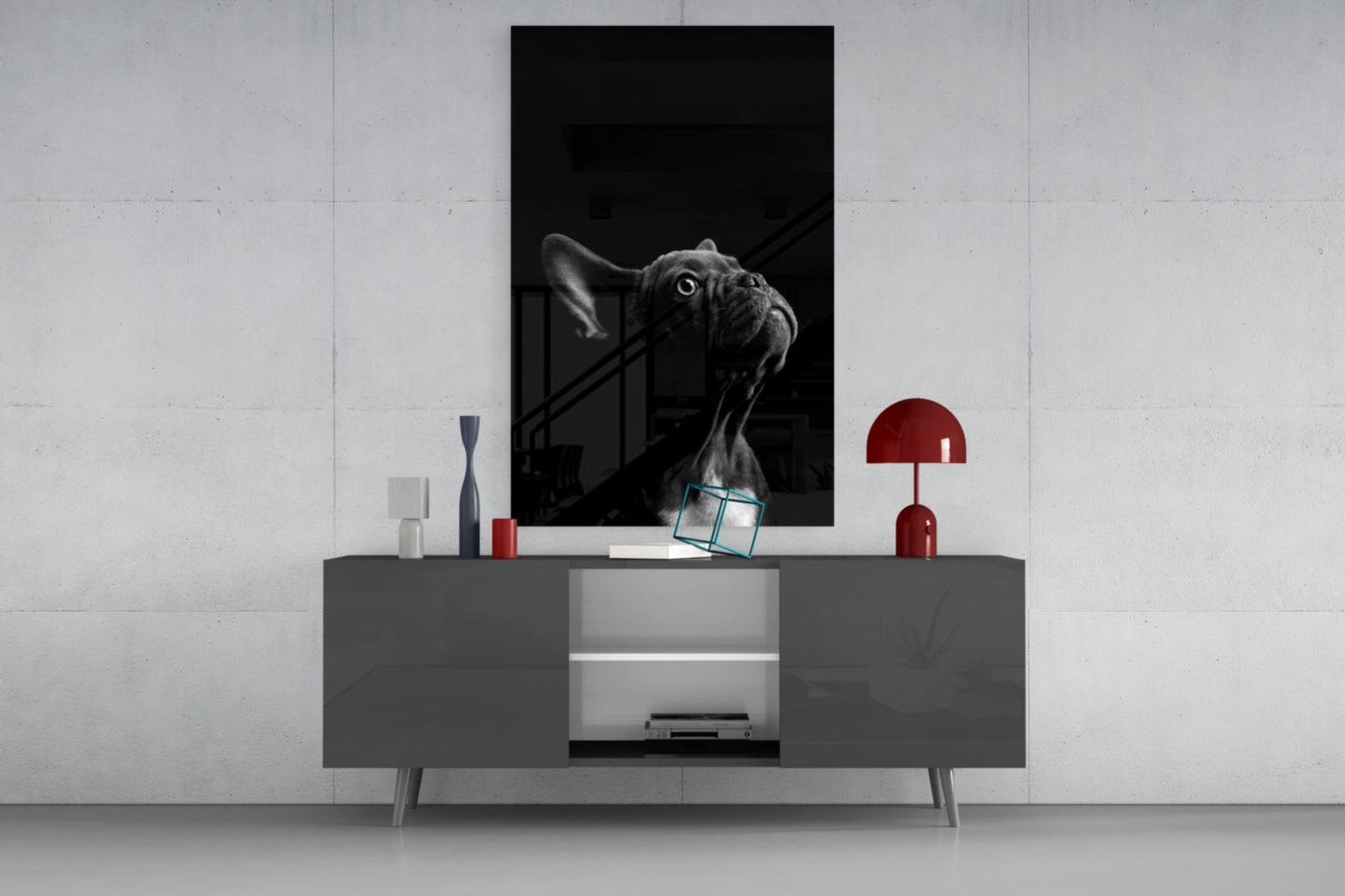 Black and white bulldog glass wall art displayed above gray media console with red lamp and decorative objects.