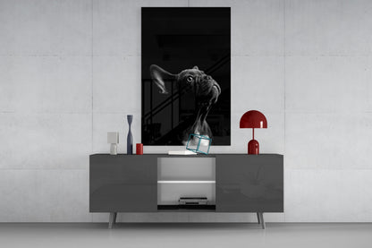 Black and white bulldog glass wall art displayed above gray media console with red lamp and decorative objects.