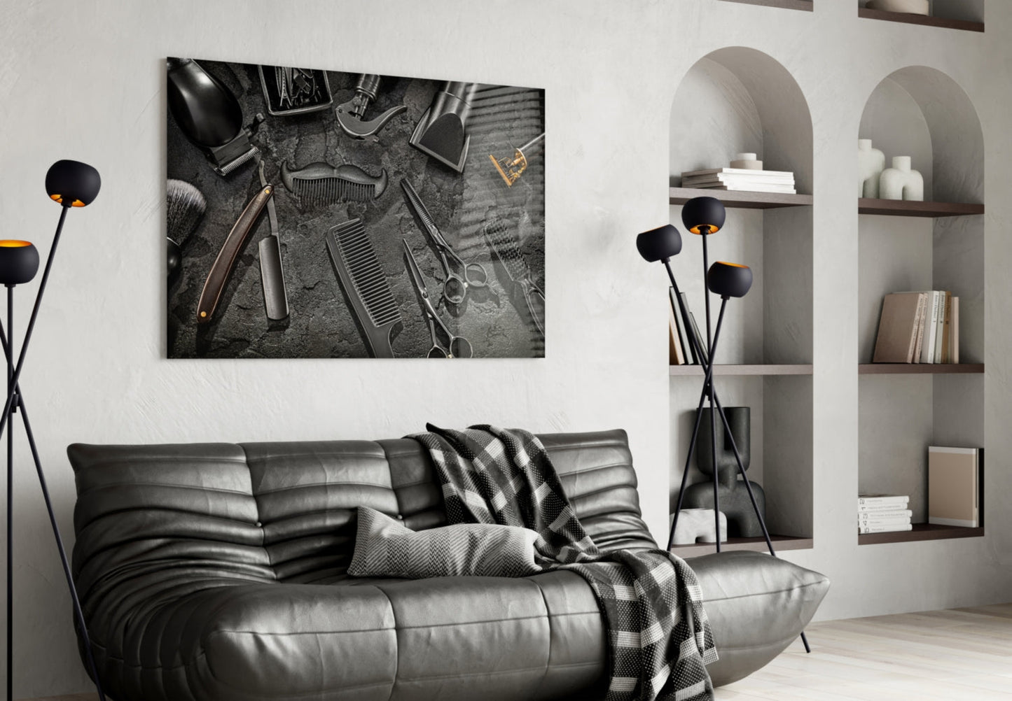 Black and white barber tools glass wall art hanging above a gray leather sofa in a modern living room interior.