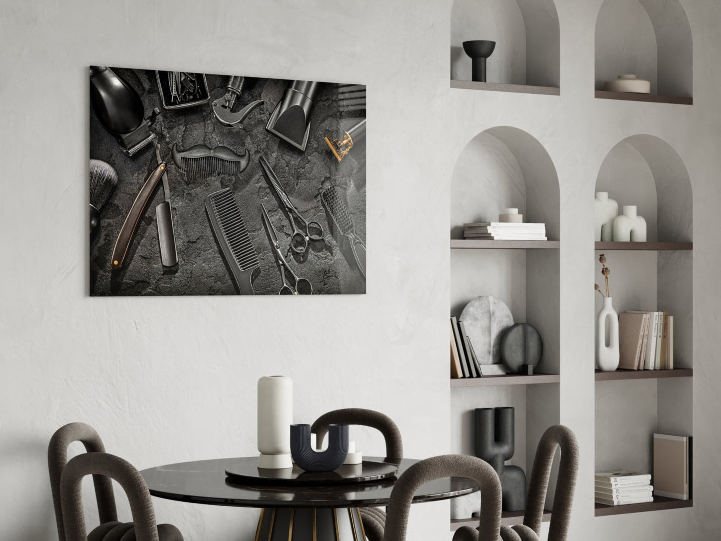 Black and white glass wall art depicting overhead barbering tools arranged on textured surface, displayed above round dining table in modern interior.