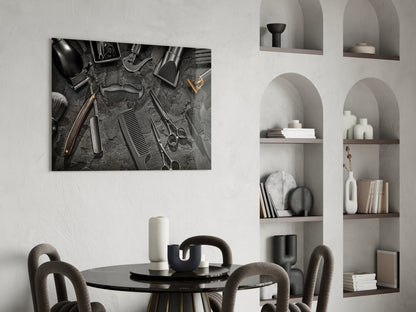 Black and white glass wall art depicting overhead barbering tools arranged on textured surface, displayed above round dining table in modern interior.