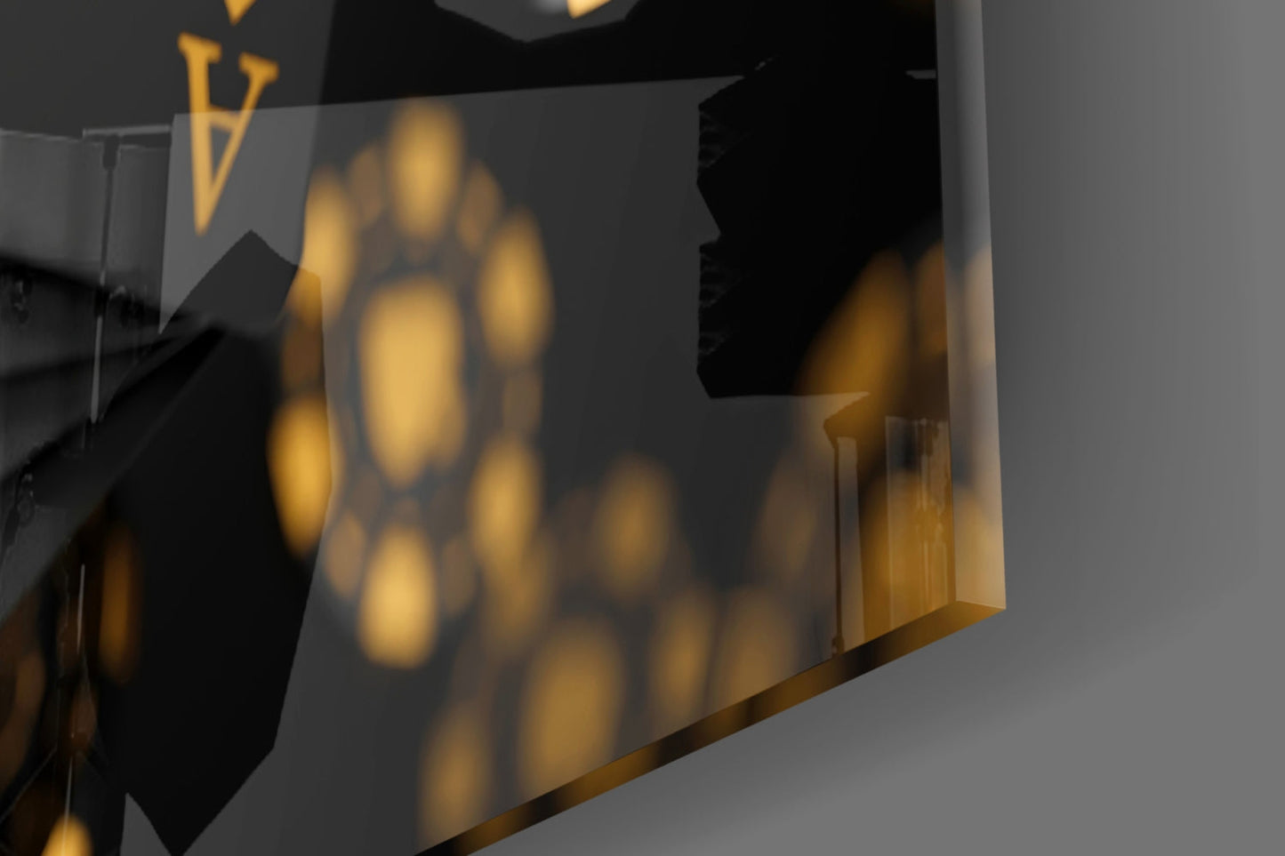 Close-up angled view of gold and black glass wall art with circular bokeh pattern and brass accents, showing depth and translucence.